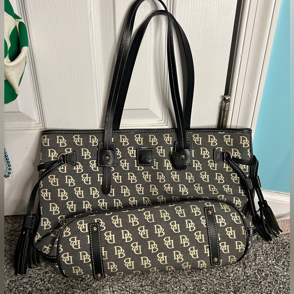 Dooney & Butke Black purse with ivory color logo pattern. Pink interior